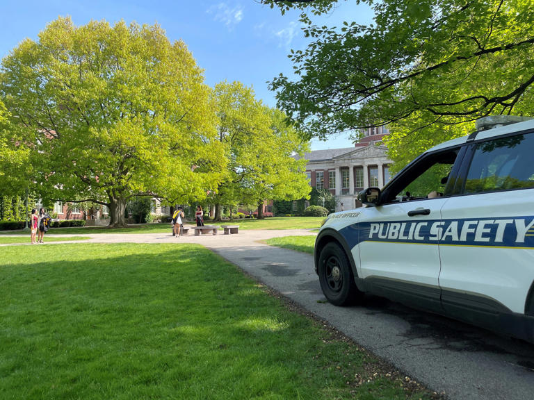 Students prepare for commencement at the University of Rochester on May 14, 2024, with Department of Public Safety officers stationed nearby.
