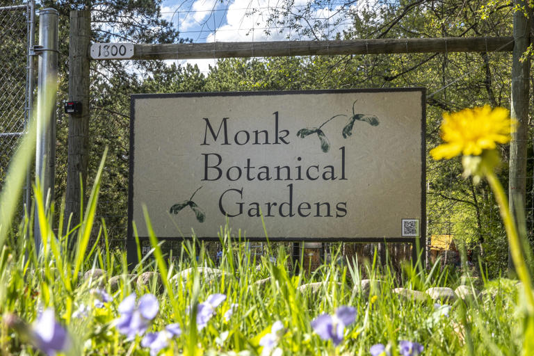 A sign with the name Monk Botanical Gardens stands in front of the Wausau gardens on May 8 as spring trees and flowers begin to bloom.