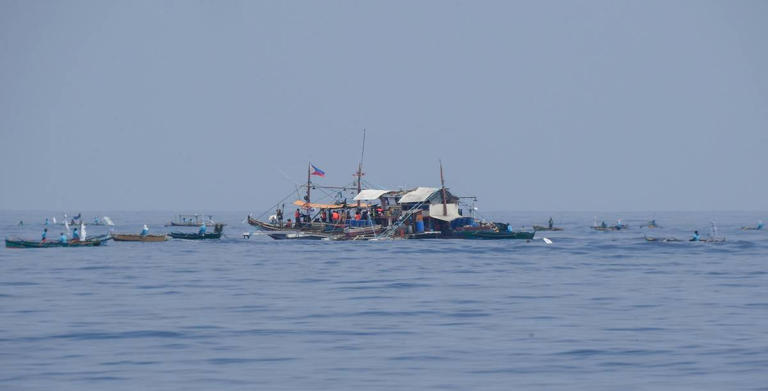 Philippine fishermen, along with volunteers from a civilian-led mission 'Atin Ito (It’s Ours)' Coalition, arrive at a meeting point as seen from the bow of Philippine Coast Guard ship BRP Bagacay, in South China Sea on May 15, 2024. Civilians on board Philippine fishing boats sailed on May 15 towards a China-controlled reef off the Southeast Asian country to distribute provisions to Filipino fishermen and assert their rights to the disputed waterway. AFP PHOTOS