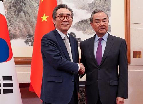 Foreign Minister Cho Tae-yul (L) shakes hands with Chinese Foreign Minister Wang Yi ahead of their bilateral talks in Beijing, on May 13, 2024. (Pool photo) (Yonhap)