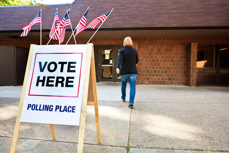 A woman enters a polling place to vote on Election Day. iStock