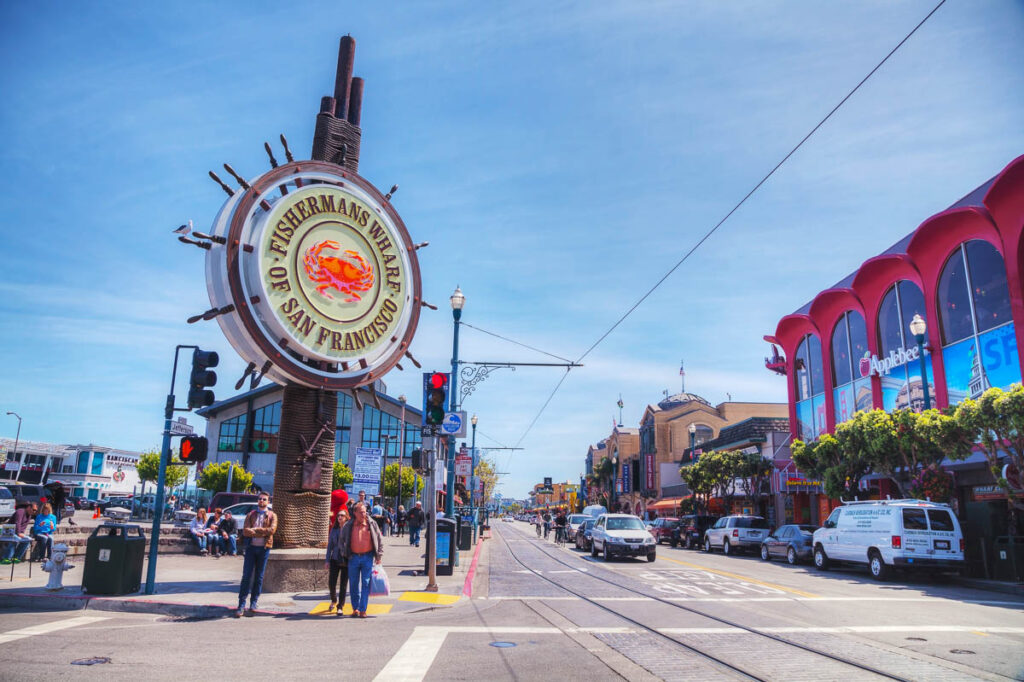 Famous Fisherman's Wharf sign with tourists on April 23, 2014 in San Francisco, California. It's one of the busiest and well known tourist attractions in the western United States.