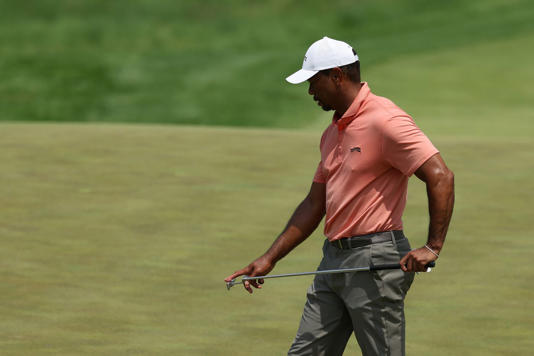 Tiger Woods eyes his putt on the 9th green.
