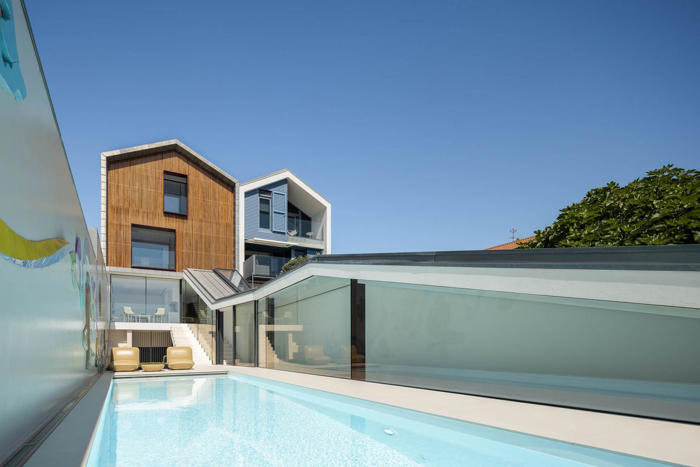 dos casas estrechas y alargadas cerca de aveiro (portugal) unidas por un precioso patio con piscina y un jardín vertical