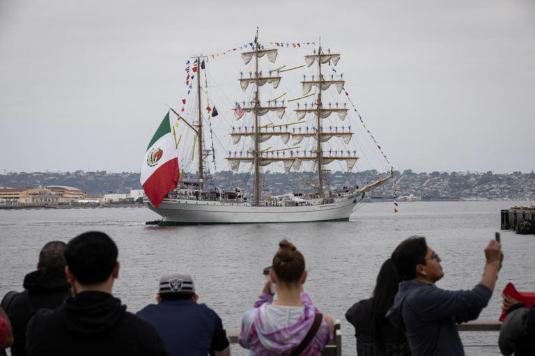 San Diego, California - May 16: Dozens of people cheer as a 261 person crew arrives on a tall ship called Cuauhtemoc on Thursday, May 16, 2024 in San Diego, California. The training ship is part of the Mexican Navy Secretariat and has been used for 41 years - traveling to more than 228 ports in 73 countries.