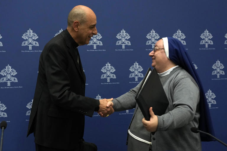 Argentine Cardinal Victor Manuel Fernandez, left, head of the Vatican doctrine office, and Sister Daniela del Gaudio, head of he Observatory on Marian Apparitions and Mystical Phenomenon, shake hands at the end of a press conference at the Vatican, Friday, May 17, 2024. The Vatican on Friday radically reformed its process for evaluating alleged visions of the Virgin Mary, weeping statues and other seemingly supernatural phenomena that have long punctuated church history, putting the brakes on making definitive declarations unless the event is obviously fabricated. (AP Photo/Alessandra Tarantino)