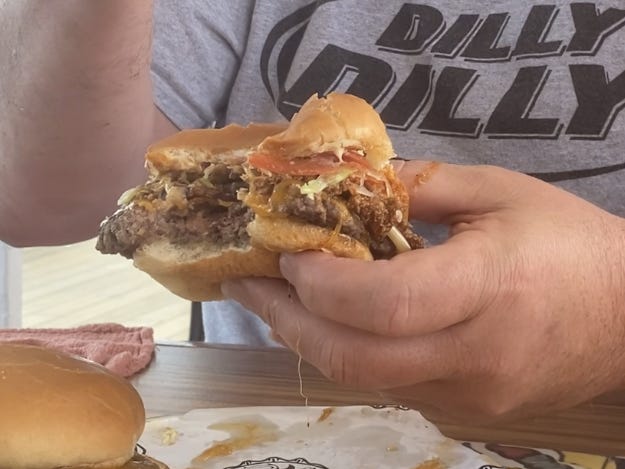 <p>The Chilius Maximus is loaded with melted cheese, chili, an onion ring, and Donkey Sauce.</p><p>I don't like chili, so I knew this burger would be my least favorite. So, I tapped on my dad, <a href="https://www.businessinsider.com/tried-making-some-of-guy-fieris-favorite-dishes-for-a-week">who loves chili</a> burgers, to give me his honest opinion.</p><p>He said the chili wasn't too spicy, and its warm notes paired well with the garlicky Donkey Sauce. But again, the onion ring did lose its crunch after sitting on top of the moist patty.</p>