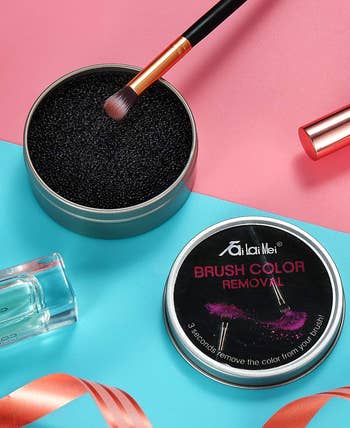 product photo of an eyeshadow brush being dipped into the container