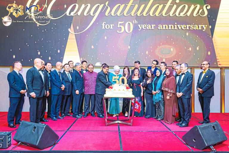Yasmin (centre, in blue) with Toh (to her left) during the cake cutting to mark the association’s golden jubilee.