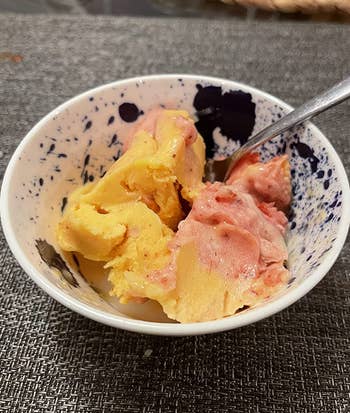 A close up of a reviewer's yellow and red sorbet