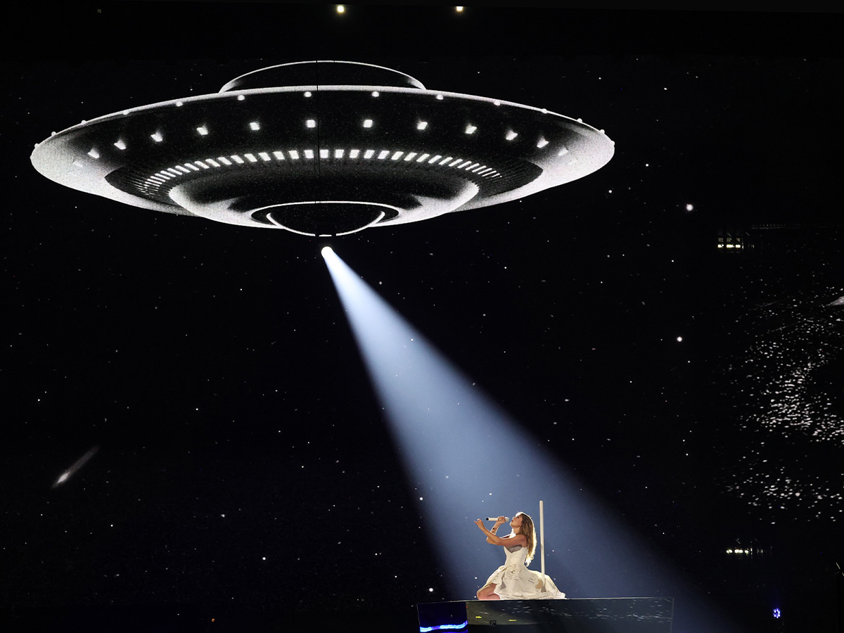 <p>For "Down Bad," Taylor wears the same TTPD wedding dress, but she shocked viewers everywhere with her new stage design. The block she lays on moves around the stage to make an infinity symbol and a UFO actually looks like it's tracking her around the stage! </p> <p> The song heavily relies on UFO and alien abduction imagery to symbolize her last relationship being so intoxicating and transportive just to be abandoned "safe and stranded" in the end. </p>