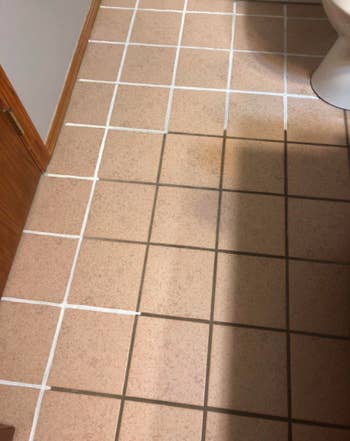 A reviewer using the pen to fill the grout, part of it is white that has been done and the other part is still brown