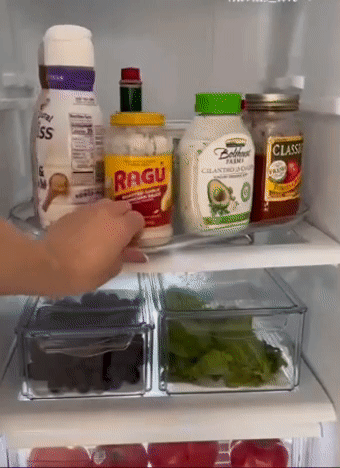 A model spinning the tray 360 degrees around in a fridge to show all the condiments on it