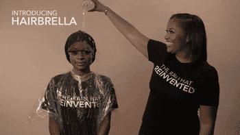 Model pouring water on another model's head while wearing the hairbrella, then taking it off to show hair perfectly styled and dried