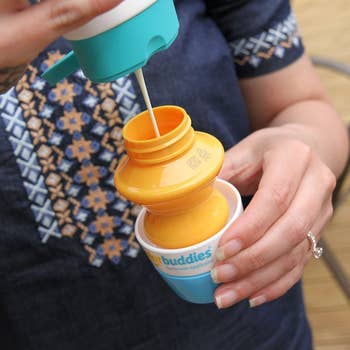 a parent pouring the sunscreen into the applicator