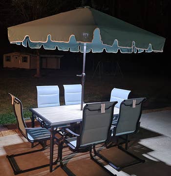 a reviewer photo of the light shining down on an outdoor table at night