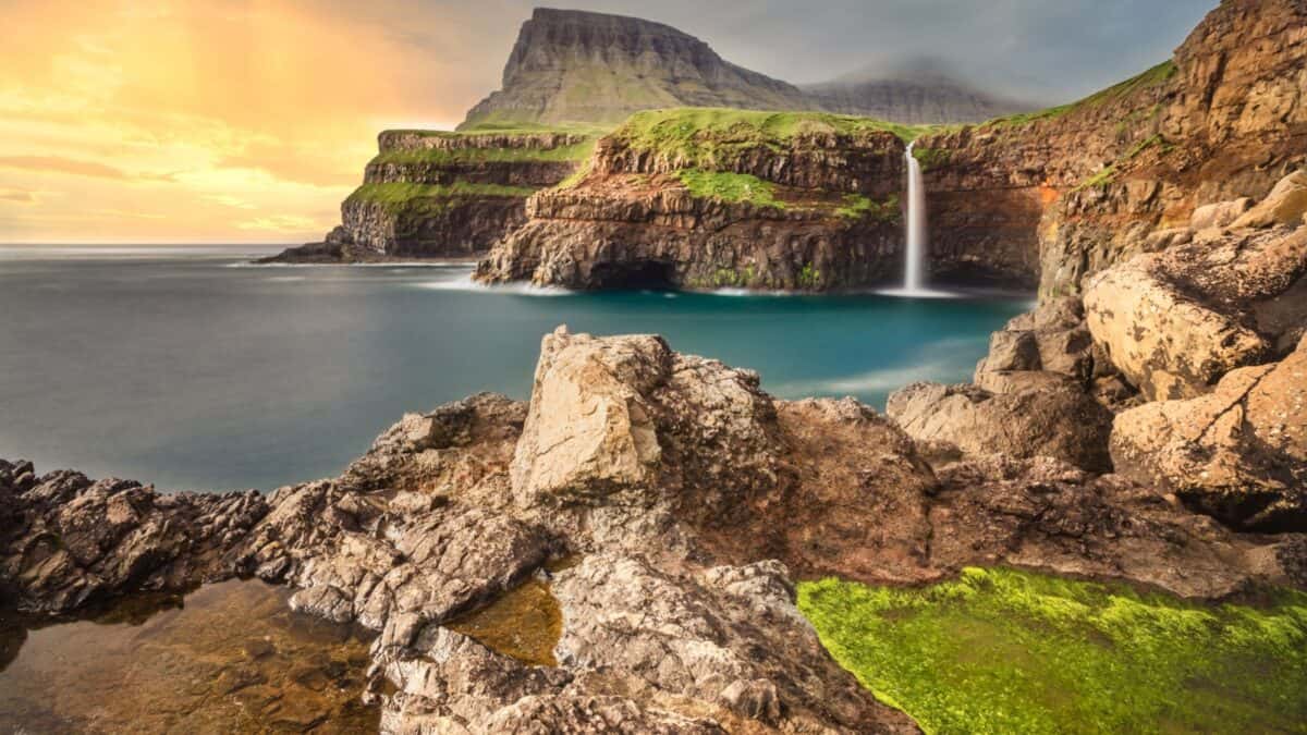 <p>The Faroe Islands, an archipelago between Iceland and Norway, are known for their rugged landscapes and unique natural beauty. With dramatic cliffs, rolling green hills, and picturesque villages, the islands offer a serene escape from the hustle and bustle of city life. </p><p>The ever-changing weather and the play of light on the landscape create a magical atmosphere, perfect for those seeking tranquility and inspiration.</p>