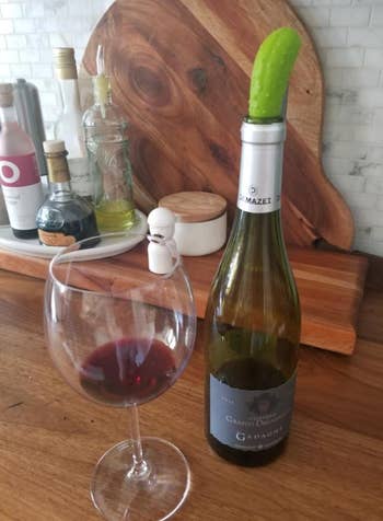The pickle inserted into the top of an open wine bottle