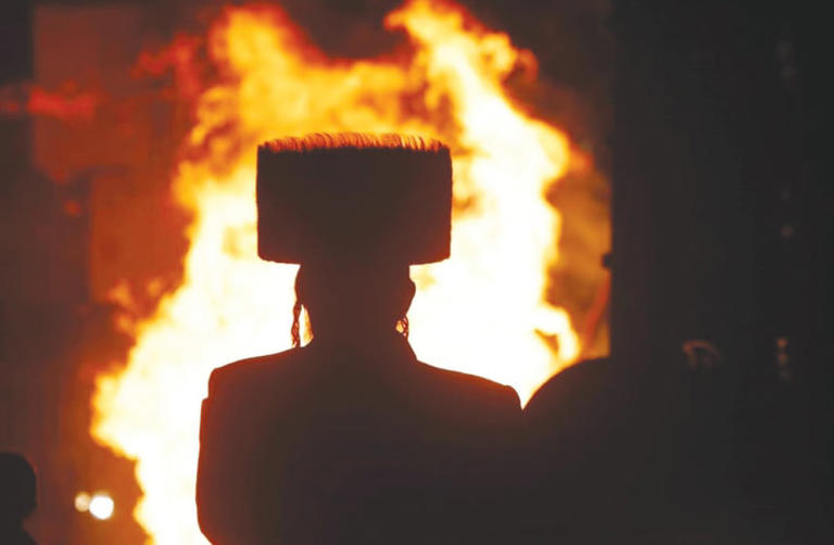  A MAN looks at a Lag Ba’omer bonfire on Saturday night in Jerusalem. The joy and warmth of Lag Ba’Omer stand in stark contrast to the pain and sorrow of the past months, the writer notes. 