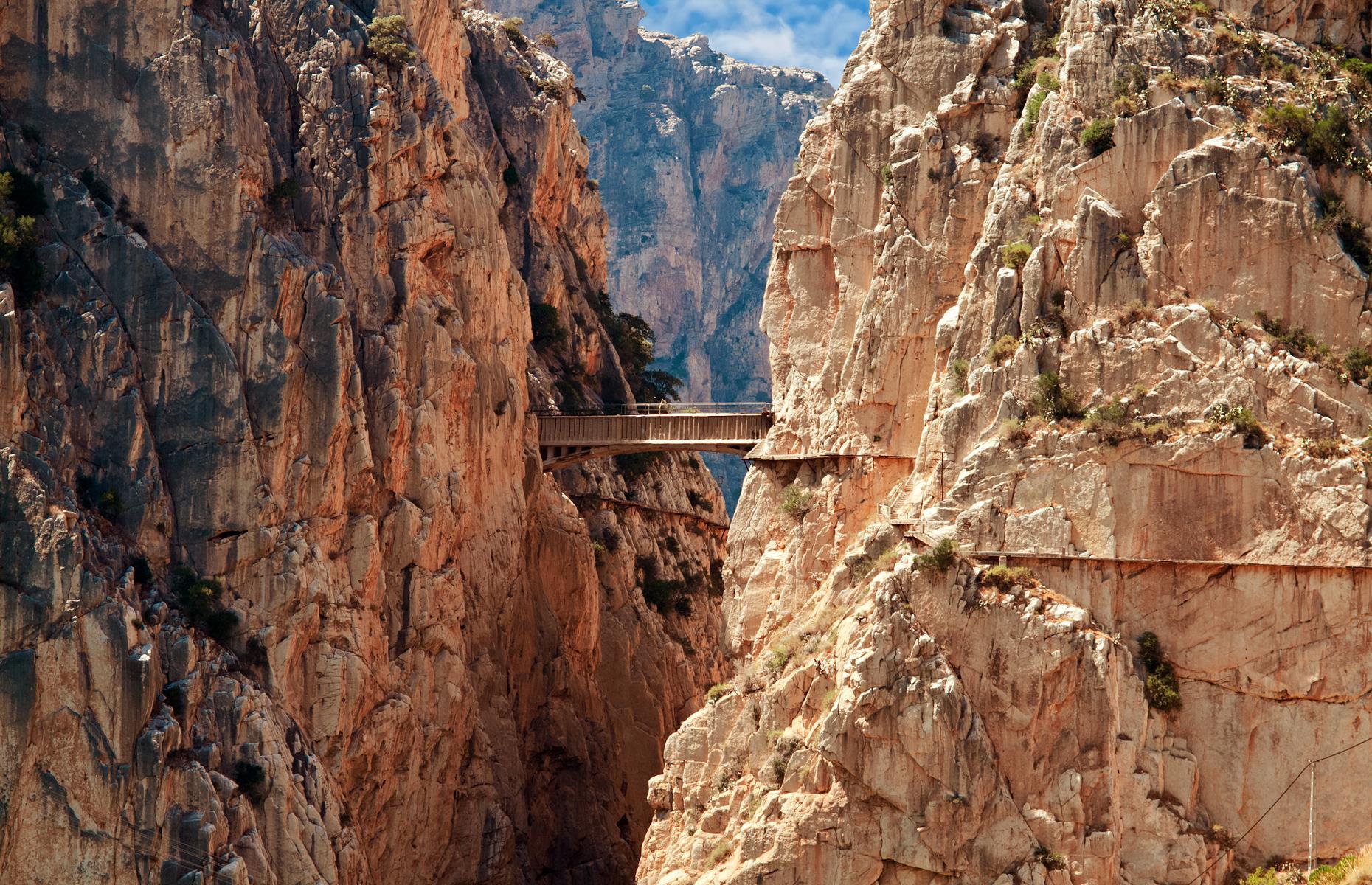 <p>El Caminito del Rey (the King’s Little Path) is a vertiginous walkway that clings to the cliffs above El Chorro gorge in the province of Malaga. Construction on the trail, made up of concrete boardwalks pinned to the cliffs, began in 1901 so workers at El Chorro's hydroelectric power station had access to the El Gaitanejo dam. As well as the narrow cliff-edge walkway, a suspension footbridge was strung across the gorge, soaring over 328 feet (100m) above the Guadalhorce River. </p>