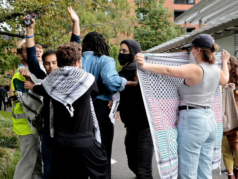 A group of demonstrators, including Harvard students Ibrahim Bharmal (left with vest) and Elom Tettey-Tamaklo (blue shirt), surrounded Israeli student Yoav Segev with his hands up at a pro-Palestinian protest on Oct. 18, 2023.