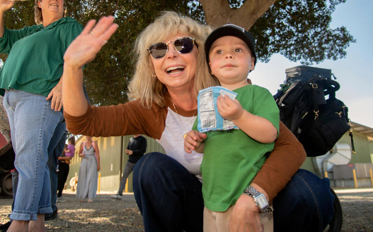 Gayla Schatz of Lockeford and her grandson Raymond Schatz of Lodi watch the tractor parade at the 3rd annual Tractor Fest on the grounds of the San Joaquin County History Museum at Micke Grove Park in Lodi on Oct. 14, 2023. About 40 vintage tractors were on display for the event at the museum sponsored by Holt of California.