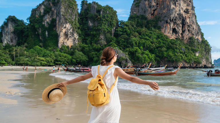 Young female traveler enjoying a summer vacation on a tropical beach in Krabi, Thailand.