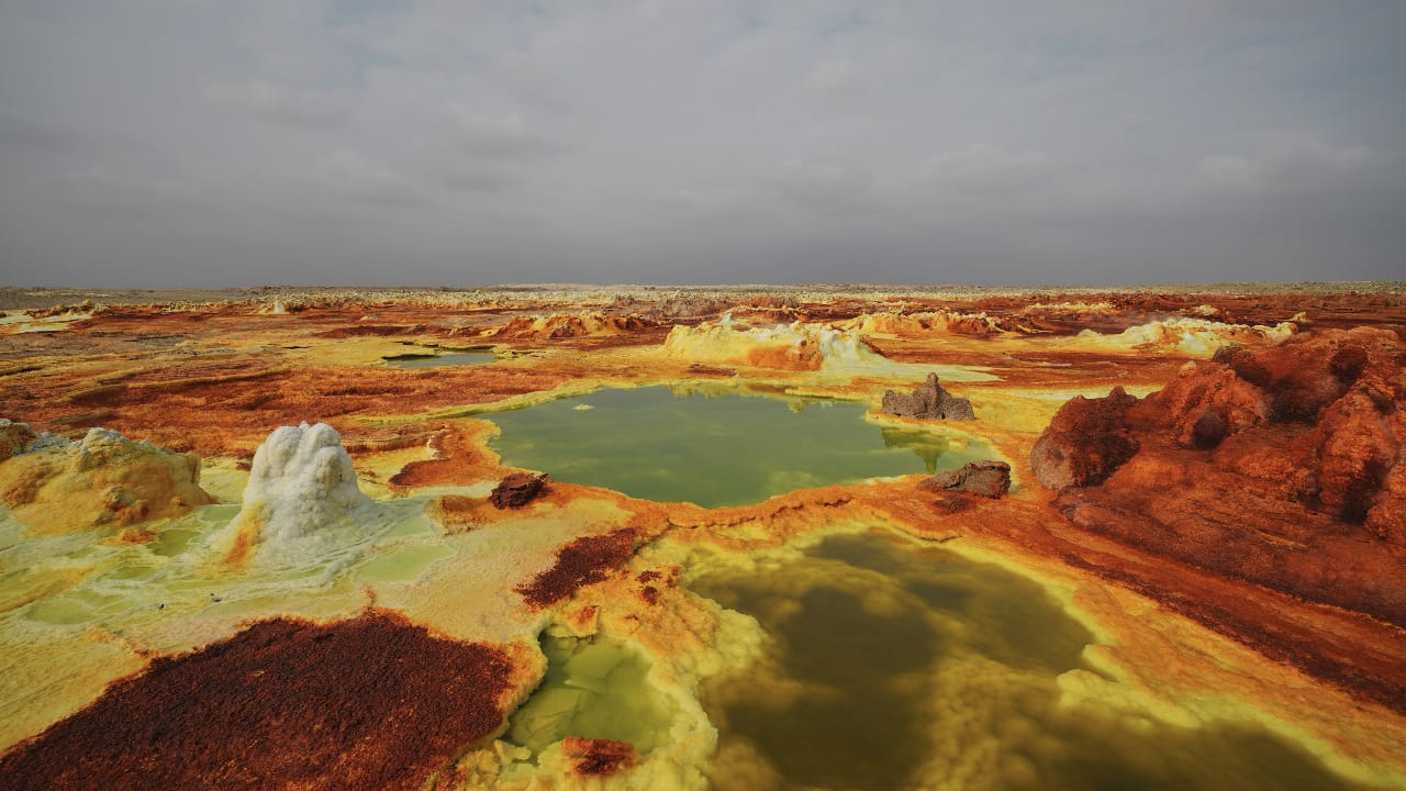 <p>The Danakil Depression, located in northeastern Ethiopia, is one of Earth’s hottest, lowest, and most <a href="https://www.cnbc.com/2020/04/09/danakil-depression-hot-and-harsh-but-travelers-love-it.html">inhospitable places</a>. This otherworldly landscape is characterized by active volcanoes, acidic hot springs, and vast salt flats.</p><p>Temperatures can exceed 120°F (49°C), and toxic gases like sulfur dioxide are prevalent due to geothermal activity. Visitors face significant risks of heatstroke, dehydration, and exposure to hazardous fumes. People do actually live in this hostile environment but survive on a diet of meat and milk since nothing grows here. </p>