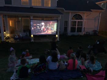 a group of kids watching a movie on the projector screen