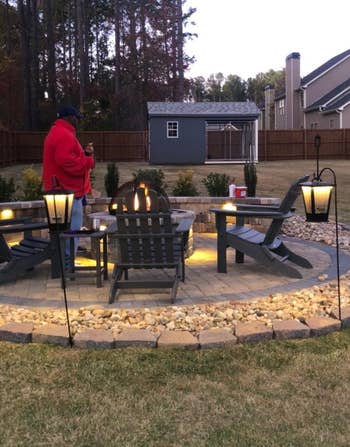 several of the led lit bluetooth speakers hung around a fire pit
