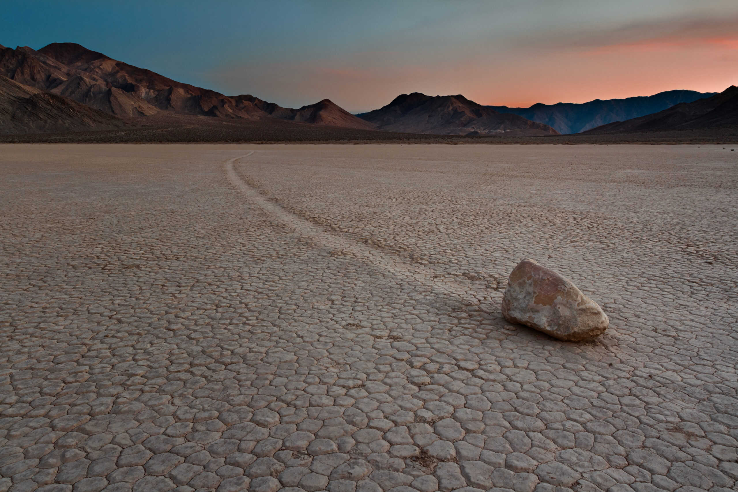 <p><span>In California’s Death Valley, the sailing stones move mysteriously across the dry lake bed known as Racetrack Playa. These rocks, some weighing hundreds of pounds, leave long trails behind them as they glide across the ground. The movement is driven by a combination of freezing and thawing cycles that create a slick surface, allowing the stones to slide effortlessly, though it appears as if they are moving on their own.</span></p>