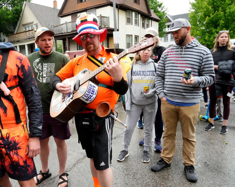 Andy Olson of Plainfield, Illinois plays his guitar before running in the Locust Street Beer Run as part of the Locust Street Festival of Music and Art in Milwaukee in 2023. The 2024 street festival is June 9.