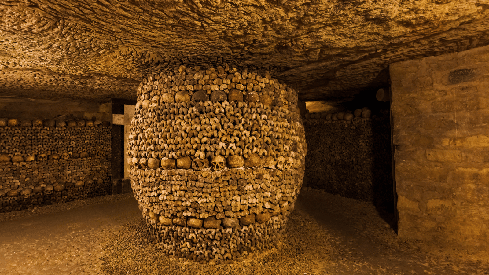<p><span>The burial site of over six million Parisians might not seem like an ideal tourist attraction, but visiting The Catacombs of Paris is an experience unlike any other. It offers a unique glimpse into the city’s history as you walk through the dimly lit tunnels lined with bones. </span></p>