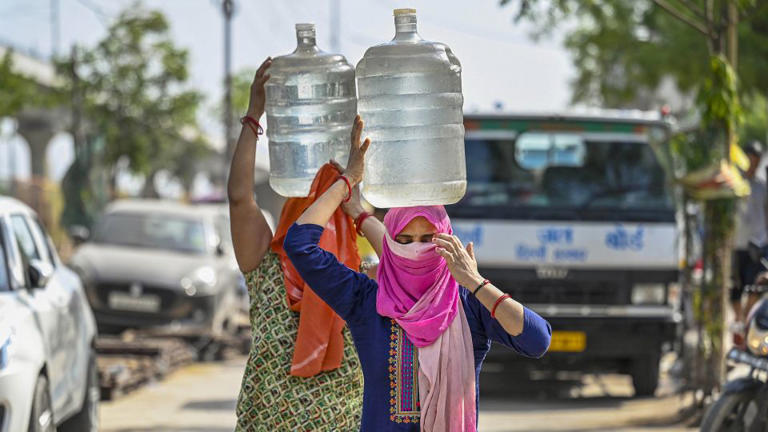 People are filling up from a water tanker during a heat wave in New Delhi, India, on June 3, 2024. In the blazing heat, people wait in long lines, hoping to fill at least one bucket. - Raj K Raj/Hindustan Times/Getty Images