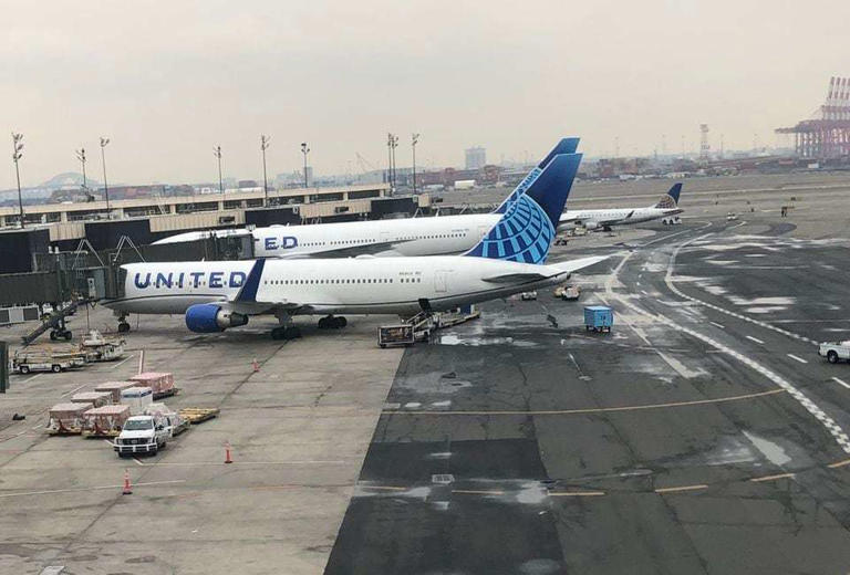 Two United Airlines jets are seen at Newark Airport's Terminal B. The airline plans to hire 15,000 new employees nationwide to address a predicted record summer air travel season.