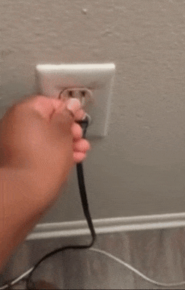 Reviewer placing a small plastic hugger into an outlet, then plugging in a device that fits securely