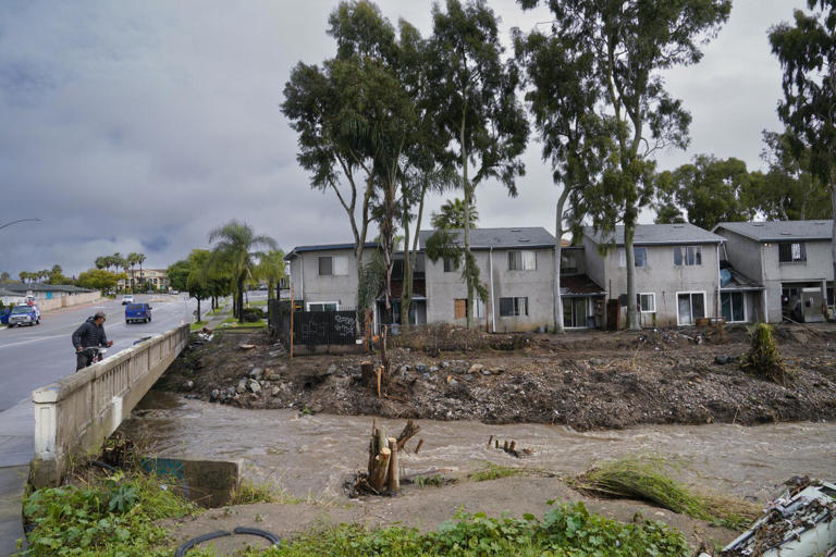 San Diego, CA - February 06: On Tuesday, February 6, 2024, in San Diego, CA, a man stops to look over the damage to the nearby apartments on National Avenue when Chollas Creek overflowed the banks back on January 22, 2024. Nelvin C. Cepeda / The San Diego Union-Tribune)