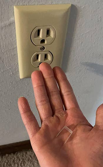 reviewer holding the plastic piece in their hand