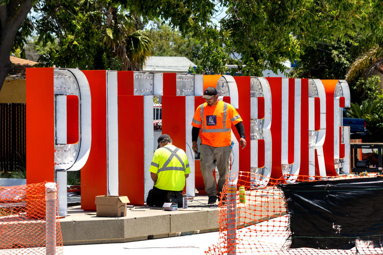 Steve Demelo and Fabian Ortiz of Arrow Signs install the 6-foot tall letters of a new Pittsburg sign on Railroad Avenue, Wednesday, May 22, 2024, in Pittsburg, Calif.