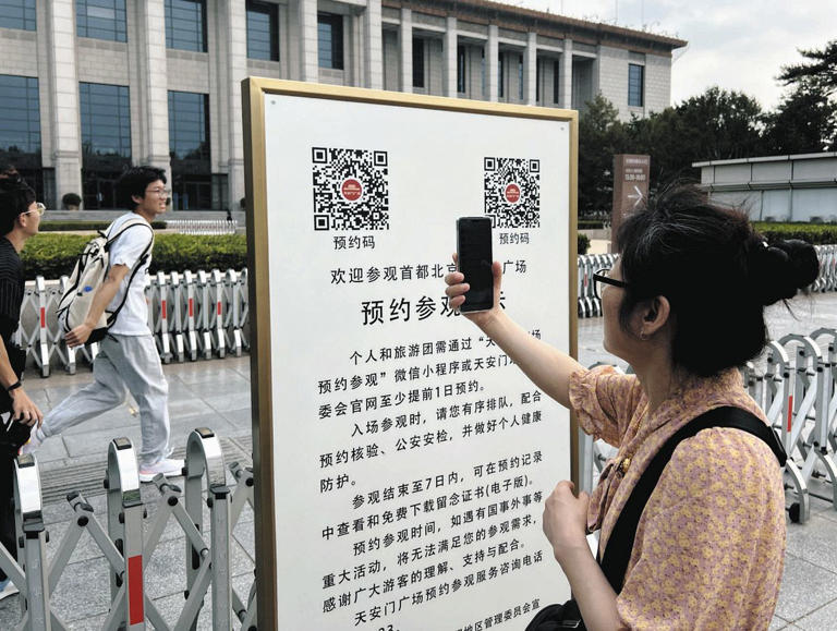 北京の天安門広場そばで、QRコードをスマホで読み込んで入場予約をする人