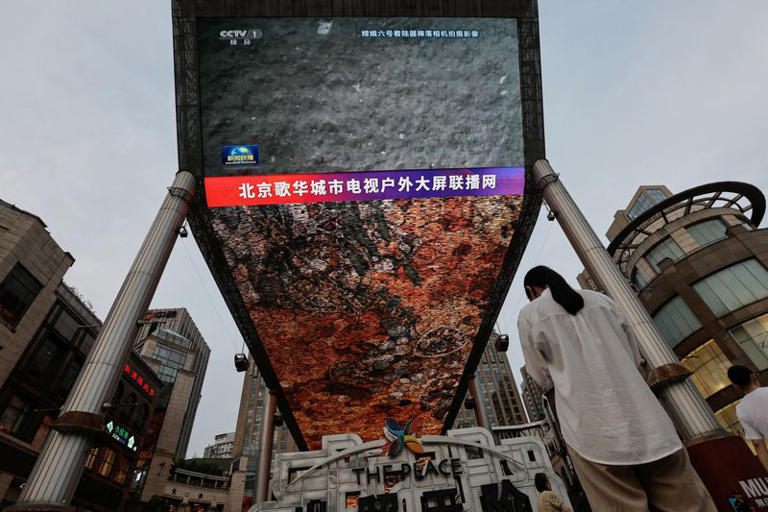 FILE PHOTO: A large screen shows news footage of the lunar surface taken with the landing camera on the lander of Chang'e-6 lunar probe, during an evening news broadcast in Beijing, China June 4, 2024. REUTERS/Tingshu Wang/File Photo