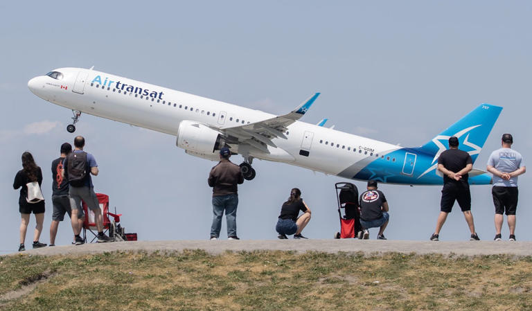 People look on as an Air Transat plane takes off in Montreal, Sunday, June 11, 2023. THE CANADIAN PRESS/Graham Hughes