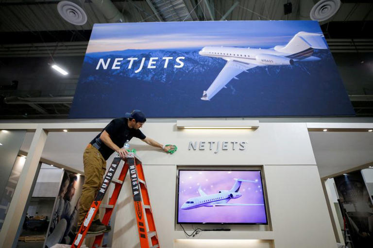 FILE PHOTO: A worker cleans a NetJets booth on the trade show floor, in preparation for the NBAA Business Aviation Convention & Exhibition at the Las Vegas Convention Center, in Las Vegas, Nevada, U.S., October 11, 2021. REUTERS/Steve Marcus/File Photo