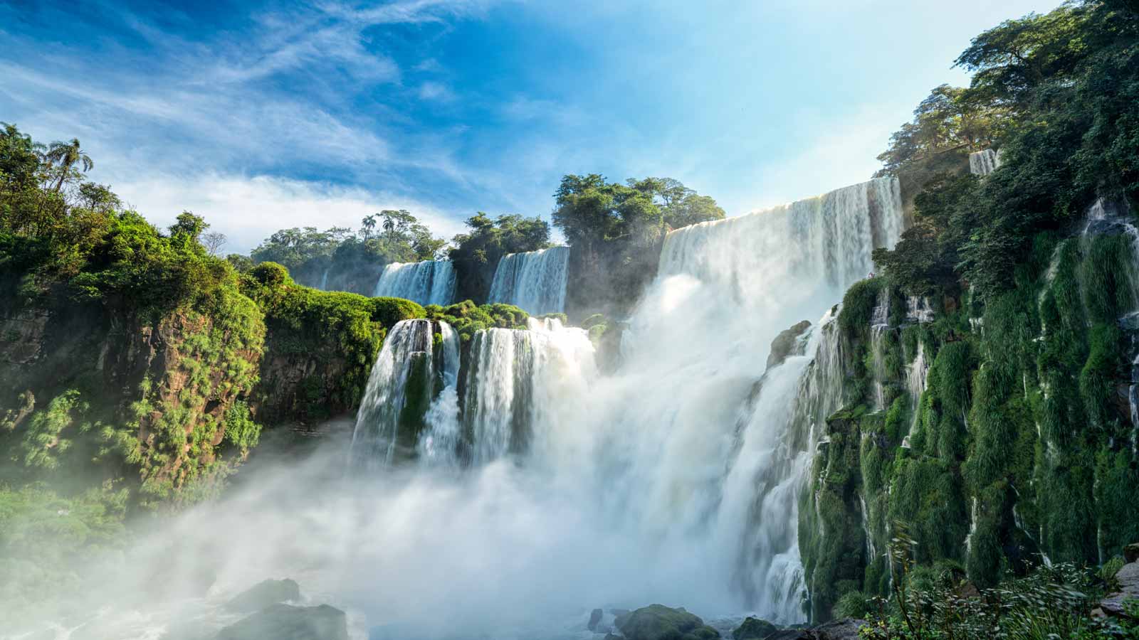 <p><span>Straddling the border of Brazil and Argentina, Iguazu Falls is the world’s largest waterfall system. It stretches just shy of two miles and features hundreds of individual waterfalls. The water plunges down approximately 230 feet, creating a breathtaking visual and auditory display. </span></p><p><span>Enveloped by a lush rainforest, the falls promise a magical, unforgettable experience. Safeguarded within a national park, Iguazu Falls is conveniently accessible from both the Argentine and Brazilian sides, ensuring a hassle-free visit.</span></p>