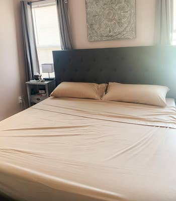 A neatly made bed with ivory sheets