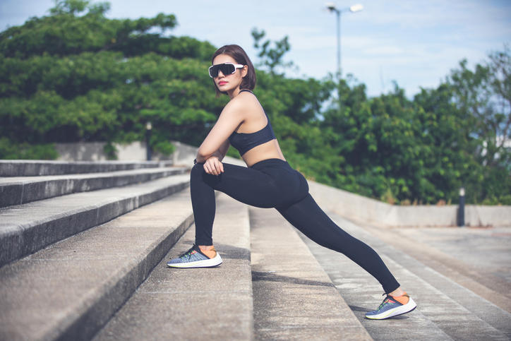 Athletic woman asian warming up and Young female athlete sitting on an exercising and stretching in a park before Runner outdoors, healthy lifestyle concept