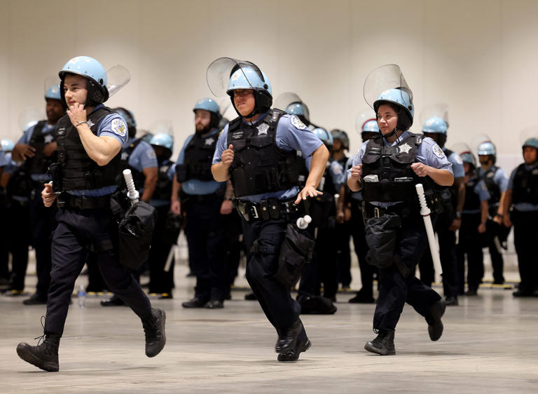 Police officers run in formation as the Chicago Police Department offers a first look at officer training at McCormick Place on June 6, 2024, in preparation for the Democratic National Convention in August.