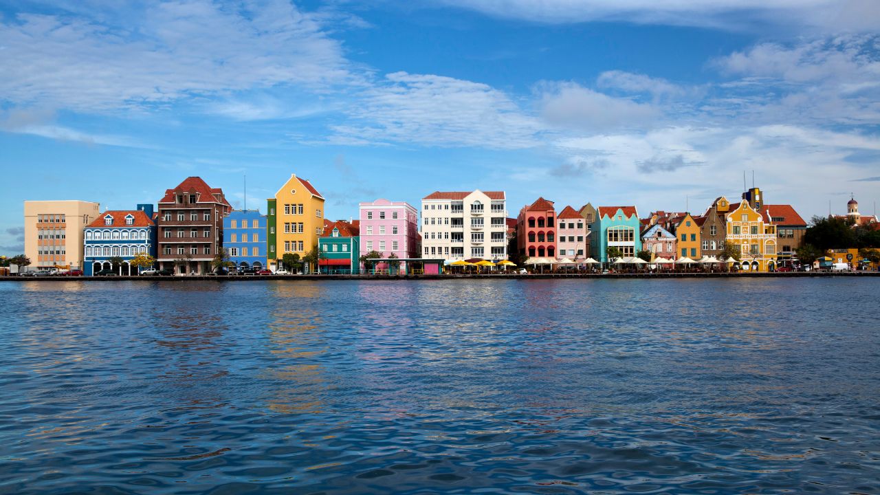 <p>Willemstad is well known for its stunning and colorful architecture, though no part of Willemstad is more beautiful than Handelskade. This waterfront area on the Punda side of the city (the eastern side of the city) is the oldest portion of Willemstad, and is marked by incredibly beautiful and colorful architecture worth a million pictures and more. Handelskade architecture is as Dutch Caribbean as it comes, with buildings that look like they could line any Amsterdam canal, but in cheery shades of pink, yellow, blue, and green. While you’ll love finding the perfect angle for photos around Punda, some of the best photos of Handelskade are from the Queen Emma Pontoon Bridge.</p>