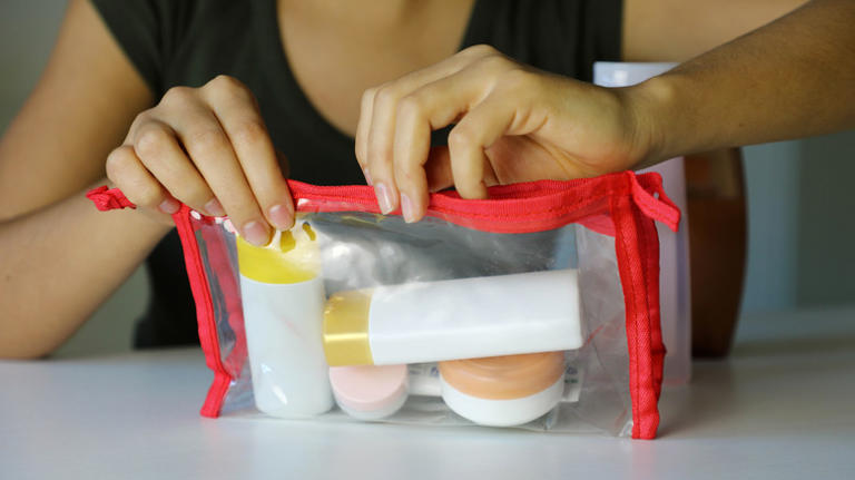 person packing toiletries