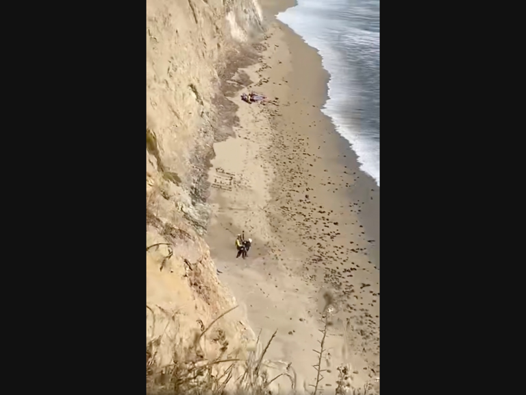 Stranded Surfer Spells 'Help' On Beach With Rocks, Rescued By Copter